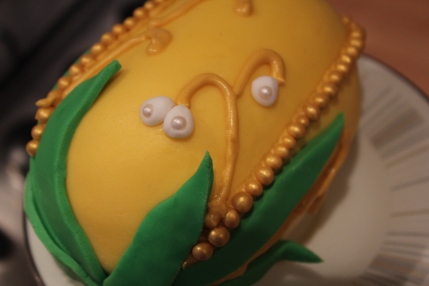 yellow faberge easter egg cake being decorated